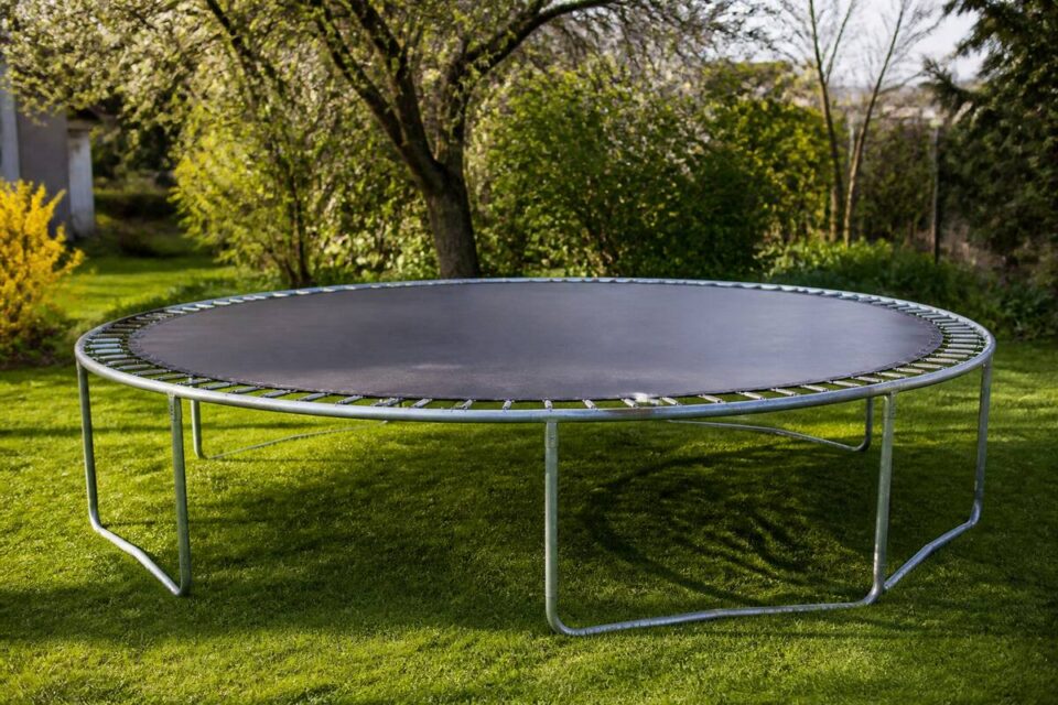 Trampoline in de tuin met zicht op springmat, frame en randkussen tijdens een seizoenscheck